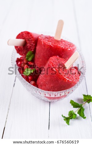 Frozen fruit popsicle on a wooden background. Selective focus.