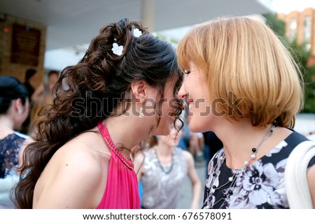 Beautiful young woman with her mother telling secrets