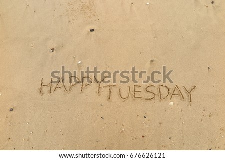Handwriting  words "HAPPY TUESDAY" on sand of beach.