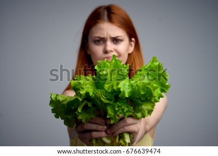 Woman with lettuce on gray background                               