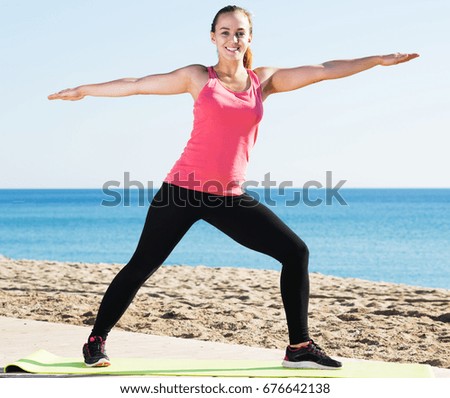 Young caucasian girl doing yoga at beach on a sunny day