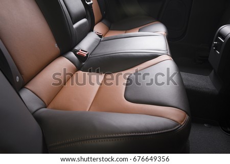 Back passenger seats in modern luxury car, side view, black and red leather Royalty-Free Stock Photo #676649356