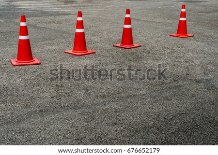 Four orange plastic cones on the asphalt road