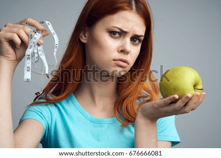 Fruit, woman with measuring tape and apple on gray background                               