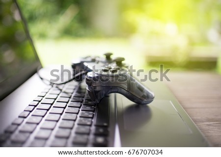 Video game controller isolated on the laptop concept Royalty-Free Stock Photo #676707034