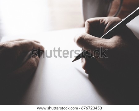 The picture of paper, pencil, laptop, coffee cup and men hand gesture above wooden table. selective focus,  soft tone