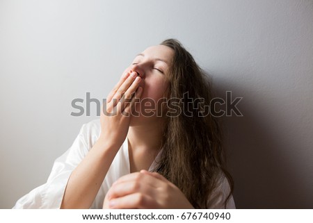 Young woman yawing, looking tired