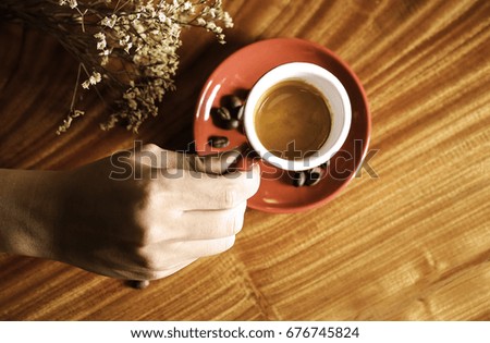 Hand hanging a cup of coffee