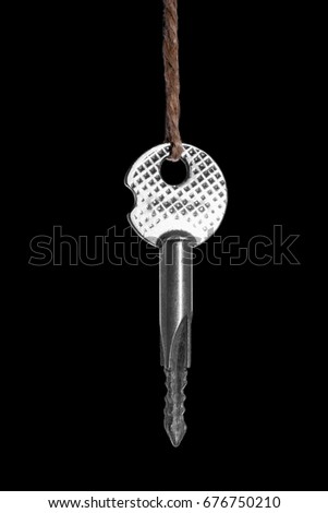 A convenient, small, light, and modern key on a black saturated background. Brilliant, shiny and gray key for the interior door, the entrance door, for the cabinet or garage.