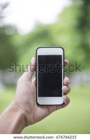 Close up man hand using smartphone in green park