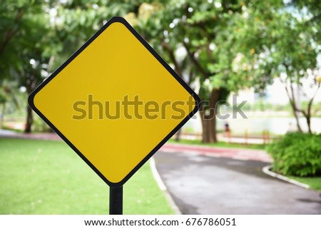 Blank yellow traffic sign at park background, copy space isolated