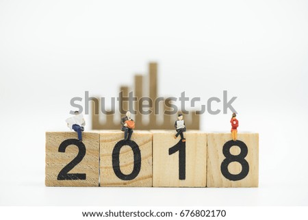 Miniature people: businessmen sitting on  wooden block 2018 text as background, success, dealing, greeting and partner concept.