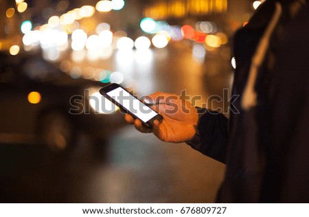 Man using his mobile phone outdoor with blank white screen, close up.