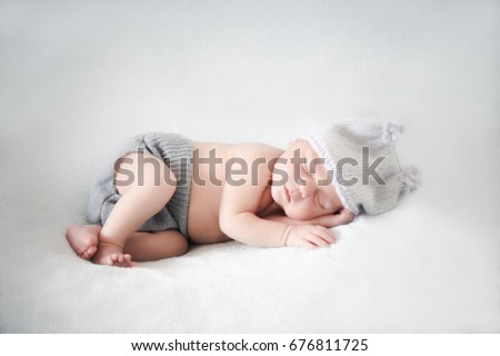 Two week old baby with hat sleeping  Royalty-Free Stock Photo #676811725