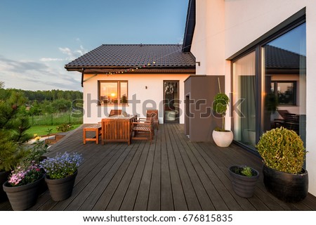 Cozy villa patio with decorative plants and wooden flooring