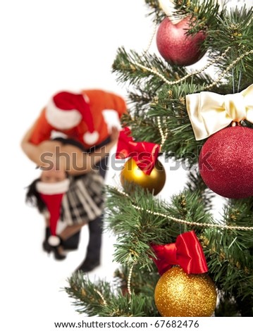 Young lovely couple near a Christmas tree with. (focus on christmas balls and fir tree )