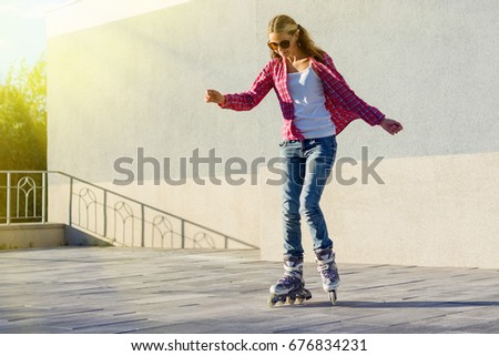 Active lifestyle people and freedom concept. 
Young woman dressed in blue jeans, rollerblading on a gray wall background
