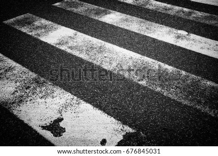 Zebra cross as a symbol for pedestrians and cars in black and white.