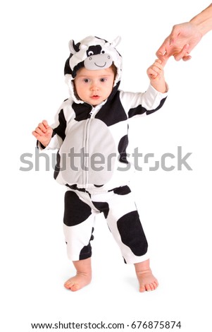 A baby in a fancy dress cow costume on a white background 