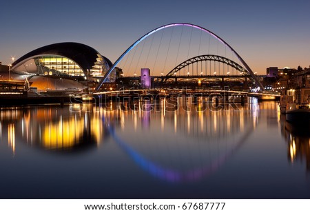 Newcastle and Gateshead at sundown showing Gateshead Millennium Bridge and Tyne Bridges. Royalty-Free Stock Photo #67687777