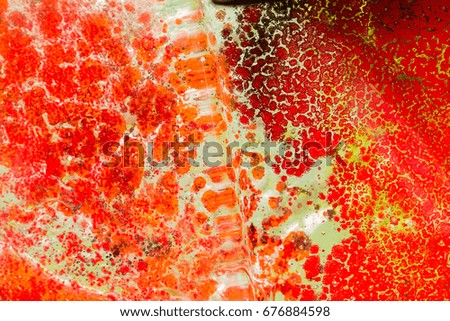 The photo a close up of abstract art glass of red color with spots and bubbles. Glass abstract background. Pattern. Glass abstract. Modern Art  deco. Decor glass. 