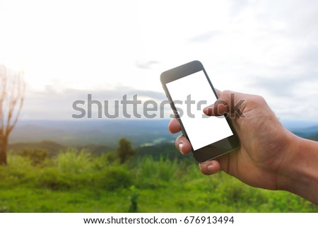 Right hand holding and showing white screen smart phone on mountain view.hand of technology