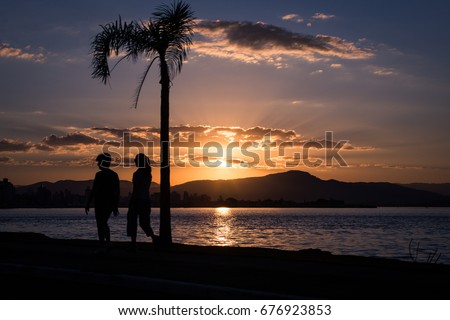 Florianopolis, Brazil - June 06, 2015: Sunset by the sea in Florianopolis, Brazil, with the silhouette of a person walking on the foreground.