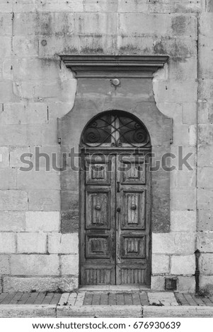 Building with traditional maltese door in historical part of Valletta. Entrance to an old house on the island of Malta. Black and white picture