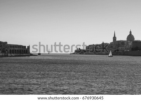 Cityscape view with Basilica of Our Lady of Mount Carmel on the island of Malta.  Yachts in the harbor on the background of city. Black and white picture
