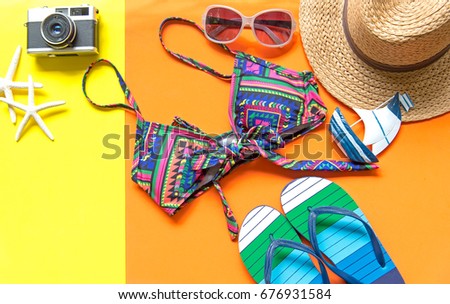 Swimsuit and sandals Unusual top view.  Summer Fashion woman Bikini. Tropical sea., colorful yellow and orange background.  Summer Concept.