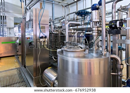 Industrial dairy production. View on the steel pipelines on the milk factory. Royalty-Free Stock Photo #676952938