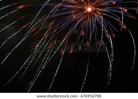Long Time Exposure of Fireworks Exploding in Several Different Color Bursts at Night on the Fourth of July