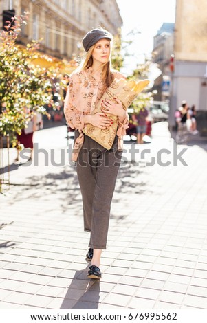 Young model stand on the street and hold bread
