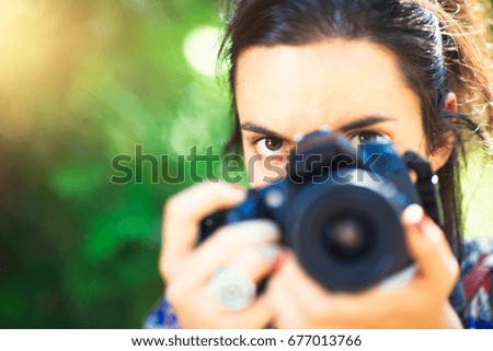 Girl photographer looks at her before she shoots.