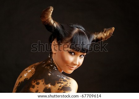 Portrait of female with horns looking at camera
