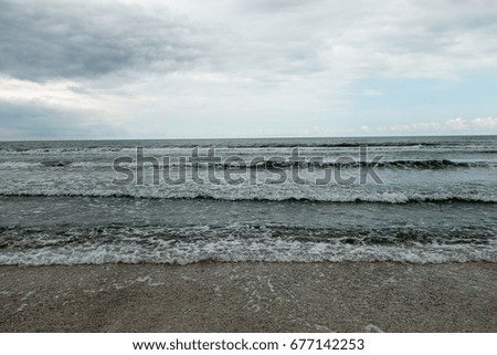 Landscape with sea view, waves and sea shells, clouds, photographed in Mamaia, Romania, in cloudy spring day