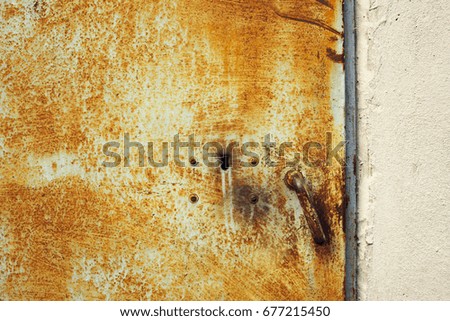 Closeup of rusted painted metal door with lock and handle