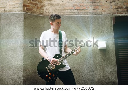 Music brings harmony to the world. Rock musician is playing electrical guitar.