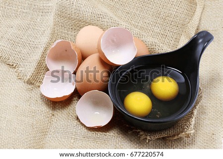 raw eggs in black bowl and eggs pile put on brown sackcloth