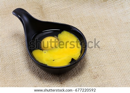 raw eggs in black bowl and egg shell put on brown sackcloth
