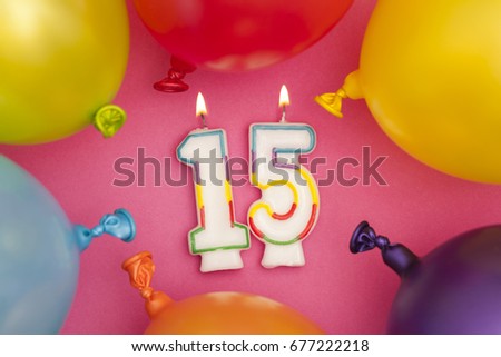 Happy Birthday number 15 celebration candle with colorful balloons
