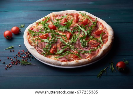 Tasty pizza on the dark wooden background