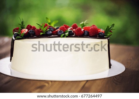 White cake with chocolate and berries