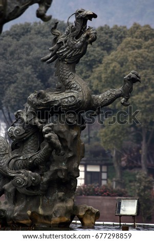 Statue of a Chinese dragon on background of trees