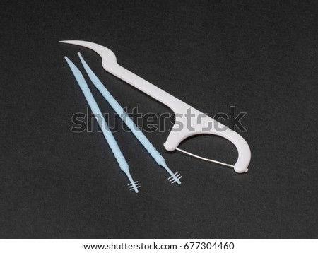 Macro shot of dental brush and floss  sticks on black background .Oral care