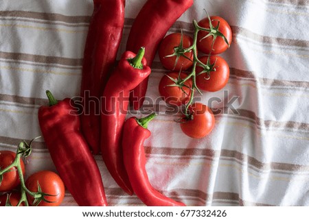 Red tomatoes and peppers on stripped cloth
