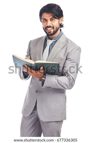 Young businessman posing with book on white.