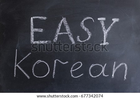The inscription "Easy Korean" is written chalk on the blackboard. Korean language learning. Getting education. Learning foreign languages.