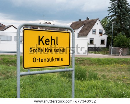 Entrance to Kehl, Germany yellow roadsign with typical German architecture real estate buildings in the bakground and inscription Kehl, Grosse kreisstadt, Ortenaukreis , 
