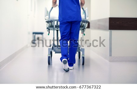 people, healthcare, reanimation and medicine concept - nurse carrying hospital gurney to emergency room